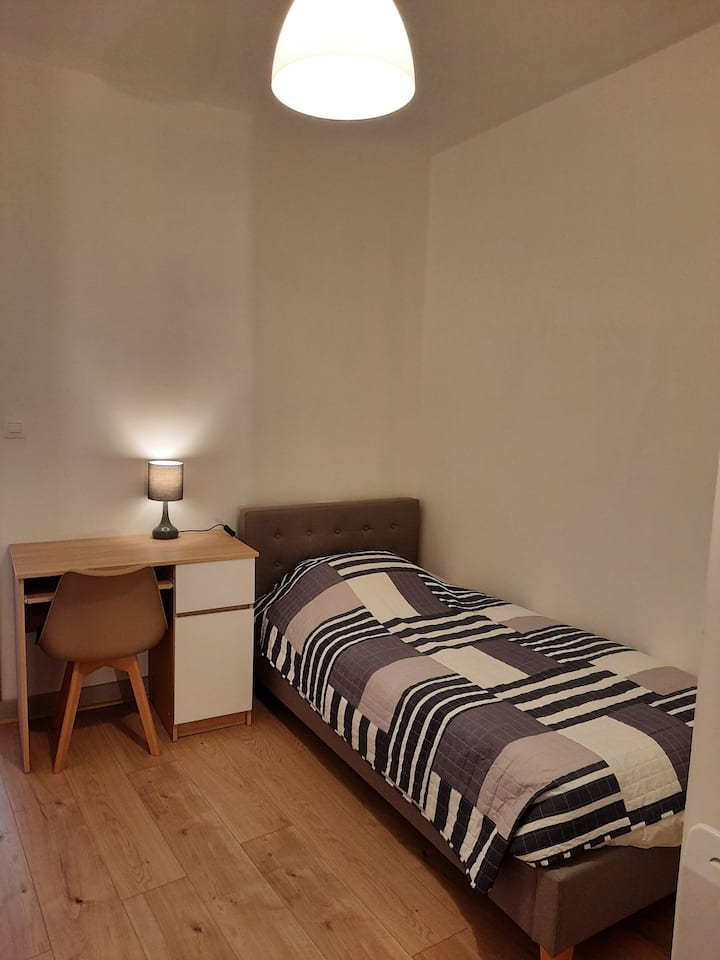 سرير لشخص واحد في الطابق العلوي، مع مساحة عمل 