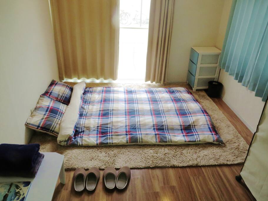 whole view of the room: There are room shoes, towels, guide book, drawer, bed, closet