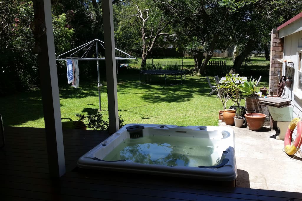 Fenced sunny backyard with spa