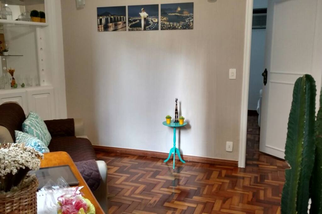 Sala confortável com Ar Condicionado, Ventilador de Teto e Sofá-Cama.
