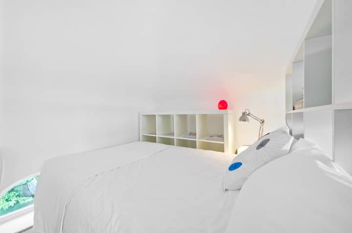 The bed with storage units to the side, reading lamp & freshly laundered bed linen. 