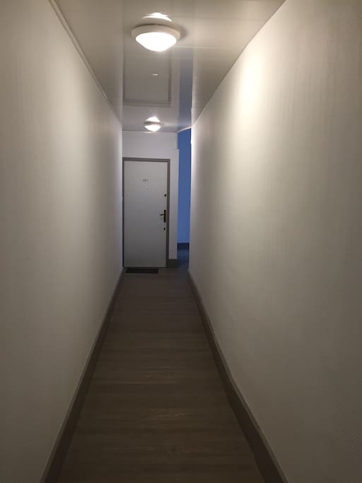 Couloir des communs menant aux appartements avec éclairage automatique.