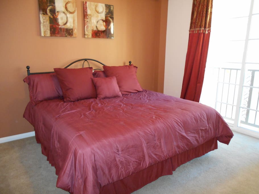 Master bedroom features king size bed and patio doors with Juliet balcony overlooking courtyard.