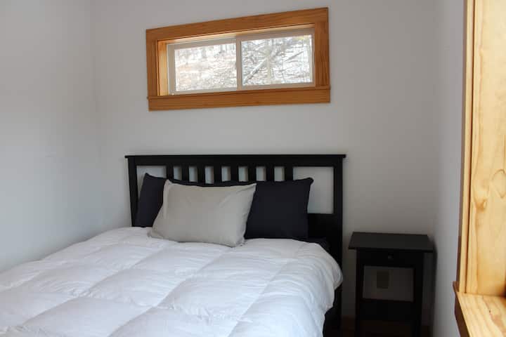 La chambre principale au premier étage dispose d'un lit queen size, d'un placard et de beaucoup d'éclairage naturel.