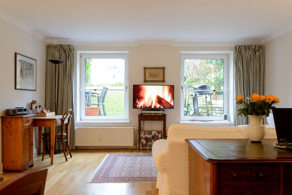 Lounge room with desk, Smart TV and garden view.