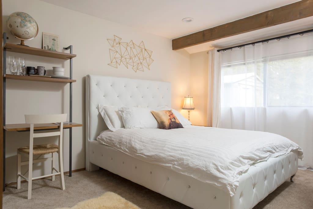 First bedroom - queen bed, desk, chair, mini fridge, Keurig coffee machine, microwave, cutlery, bowls, plates, luggage rack, full length mirror, hangers, digital alarm clock, blackout curtains and soft guest bathrobes