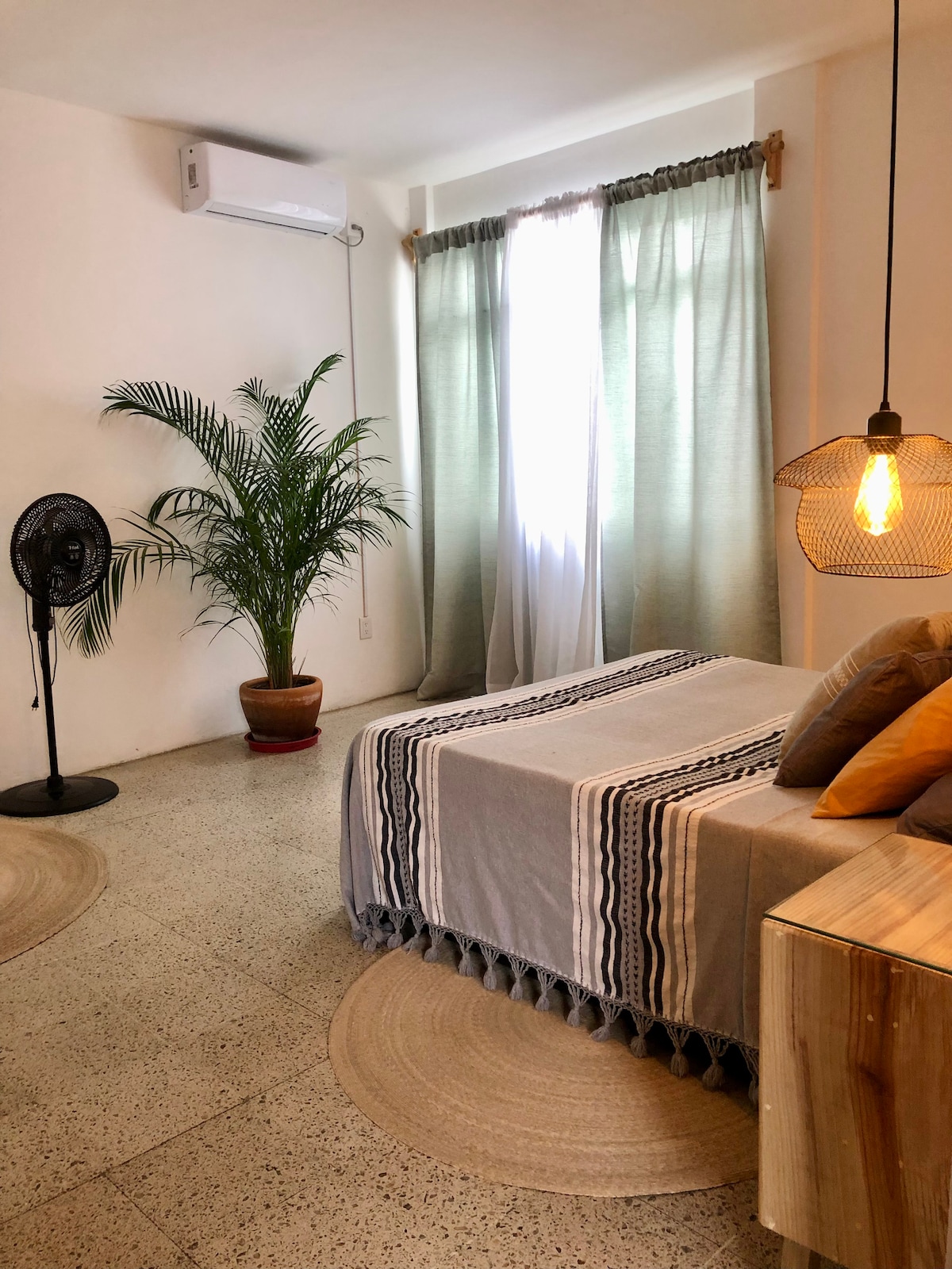 חדר שינה עם מיטת קווין סייז ומזגן. 