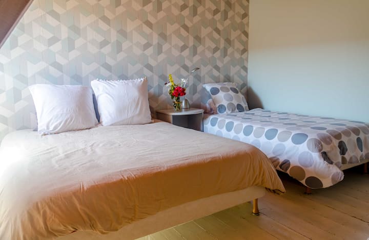 Upstairs, this second bedroom can accommodate an entire family thanks to its double bed + 2 single beds.