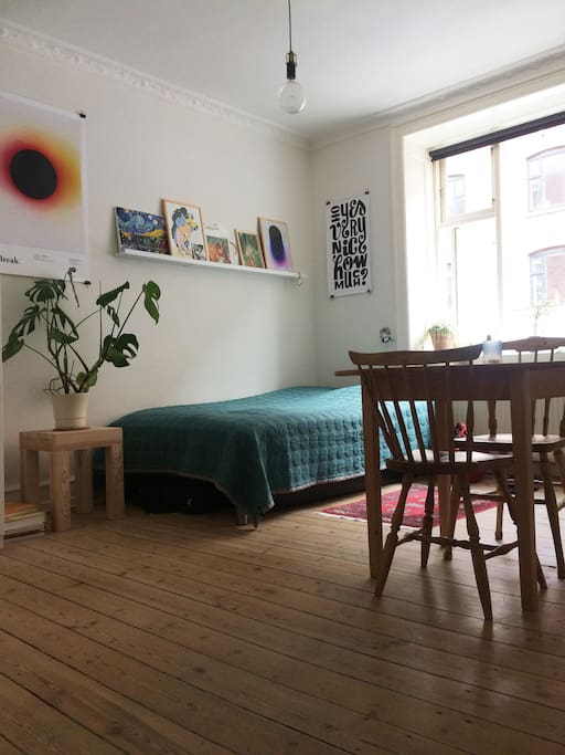 The living room has a double bed, work space and windows to the street