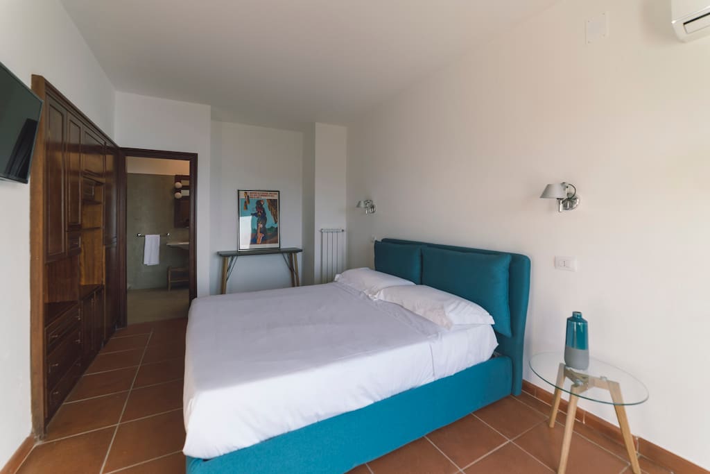 Camera elegante vista mare dotata di letto matrimoniale, con bagno privato. Pavimento in cotto Toscano pregiato e accesso diretto al giardino.