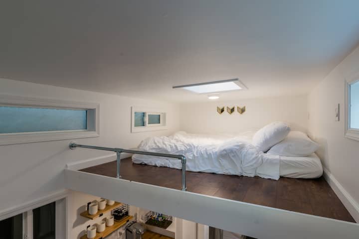 Loft para dormir con tragaluz.  La altura es de 3'5" y tiene una barandilla de seguridad.  Cómoda cama tamaño queen con 4 almohadas