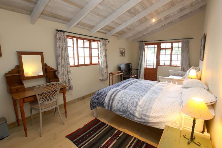 Spavaća soba na katu s bračnim krevetom i krevetom za jednu osobu. Vodi do vanjskog balkona.