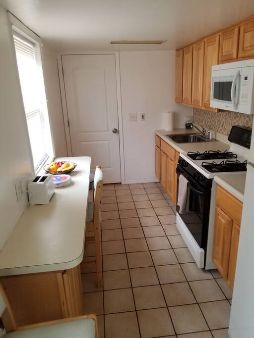 Kitchen with stove including overhead microwave and refrigerator.