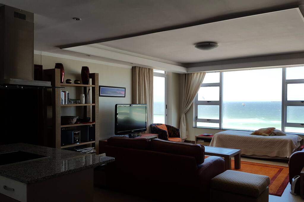 Open-plan kitchen and lounge with sliding door onto balcony