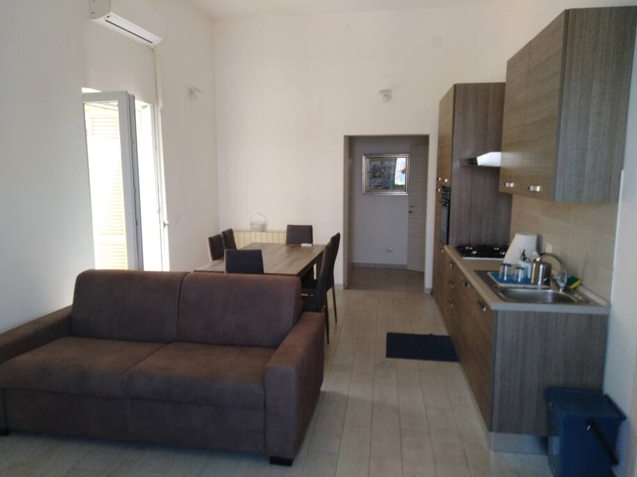 Entrata lounge con divano letto matrimoniale e cucina fornita di tutto.