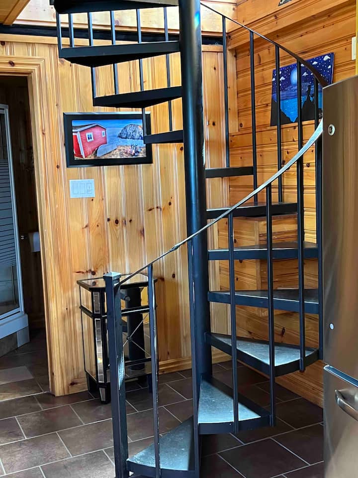 Cast iron staircase leading to first level from the master suite.  

This space is a living room kitchen combo.  