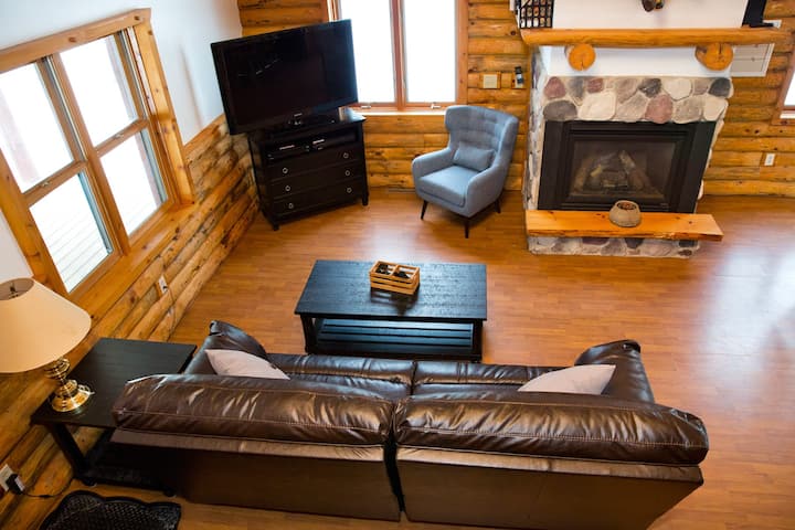 Looking over living area from loft.  Enjoy a reclining leather couch great for naps. Watch satellite TV on a 52" big screen tv. A gas fireplace will keep you warm. 