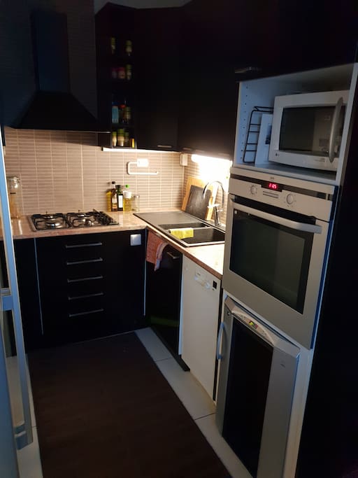 Kitchen including example gas oven, washing machine,fridge, wine cabin, coffee maker