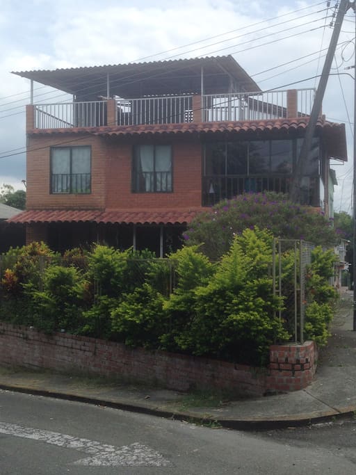 Vista frontal de la casa y jardín.