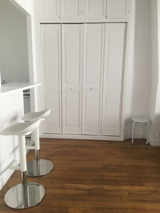 Small kitchen with bar table and stools. Inside wardrobe