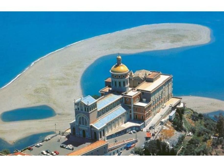 santuario della Madonna nera del Tindari con la lingua di sabbia dorata e i famosi laghetti di marinello .Santuario della Madonna nera