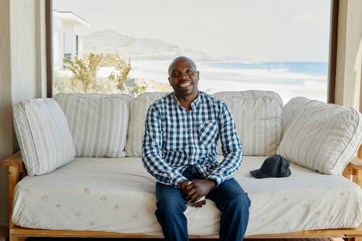 black man smiling on a couch