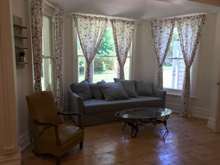 a living room with provincial widows facing private garden