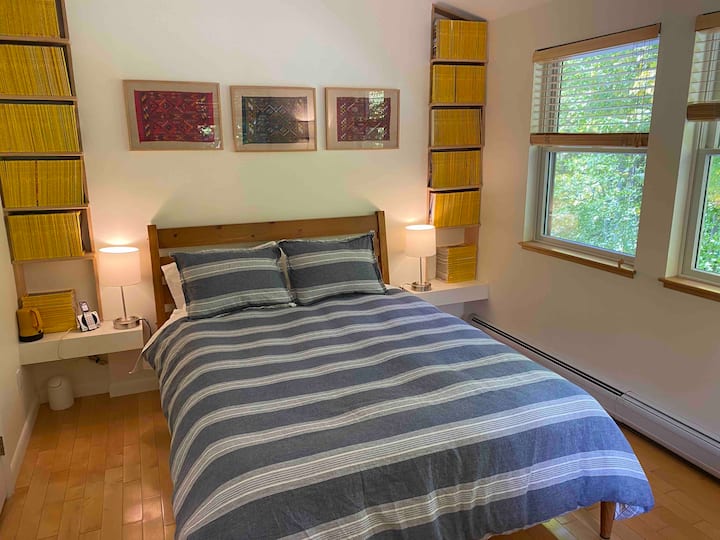 Second bedroom upstairs has a queen size bed, two rocking chairs, a table with television, and decades of National Geographic magazines.