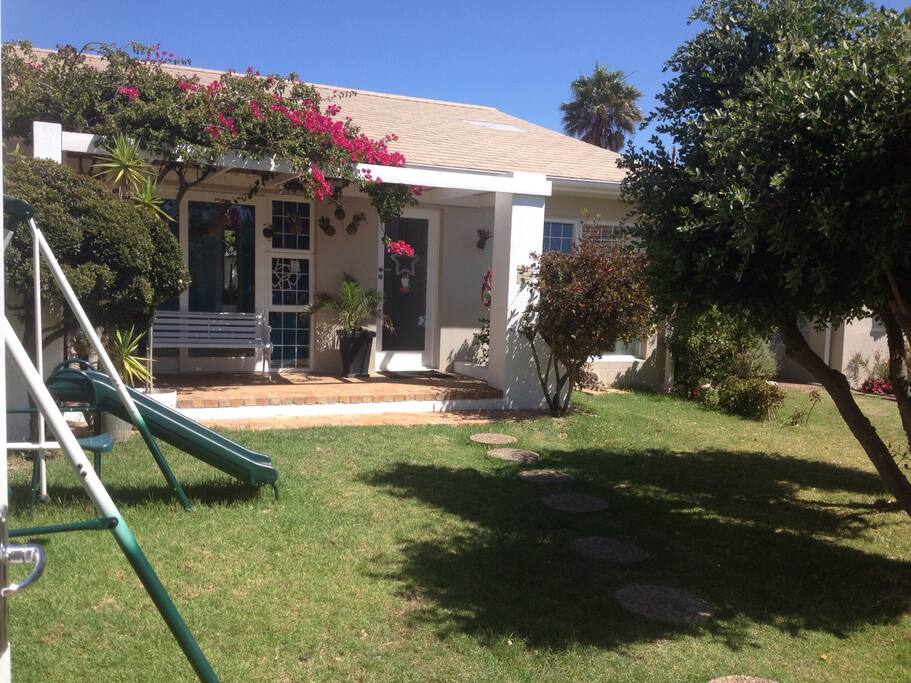 Front yard, entrance to the house, swings and beautiful pink Bougainville
