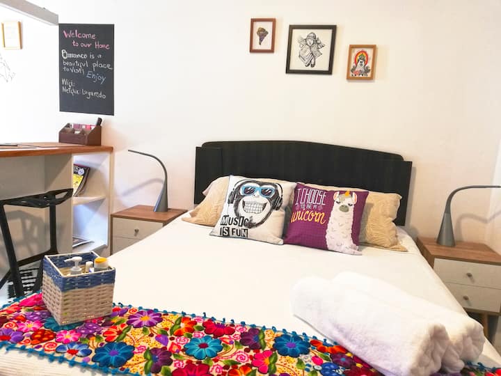 Bedside lamps include USB charger for mobile phones. The wall decorated with local artists' paintings. 