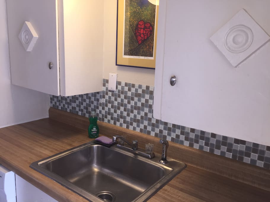 Kitchen with dishwasher, plates, cups, silverware, offee maker (coffee included)