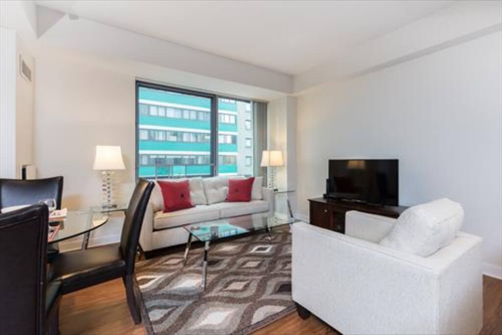 The Living Room features a work desk with chair, flat panel LCD TV with cable channels, DVD player, and stereo CD system.