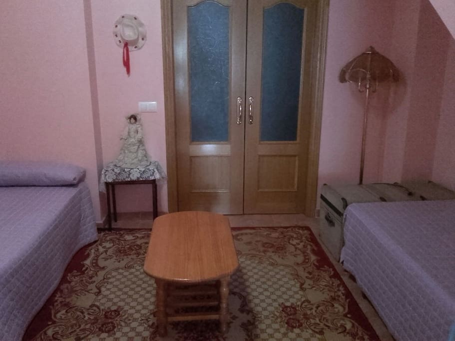 Première chambre avec 2 lits individuels, et portes qui donnent sur le salon.