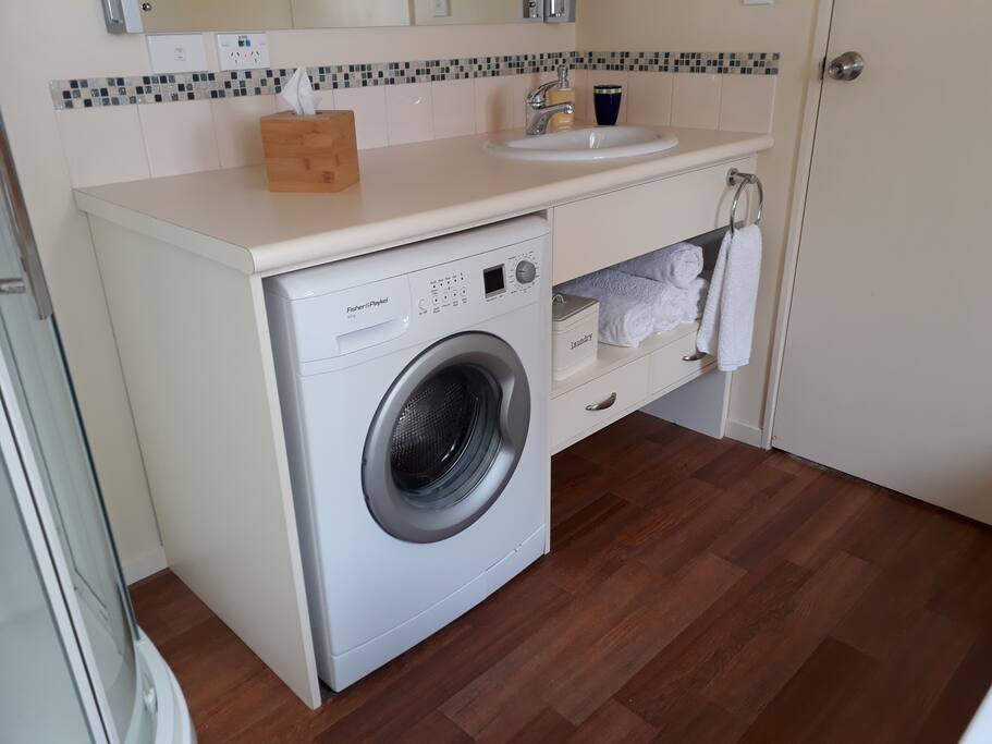 The bathroom also has a front loader washing machine