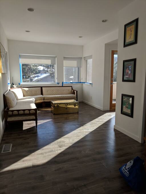 Main living room as seem from bedroom door. Tons of windows!! (don't mind the painting tape ♀️)