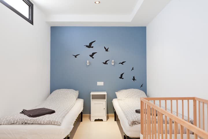 Under-built bedroom 1 with single beds and space for baby bed if needed. All bedrooms have AC.