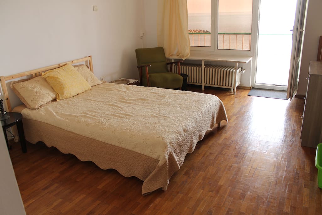 Main bedroom with doors leading to the Seaside balcony, second bedroom/ hangout space, and bathroom/ kitchenette.