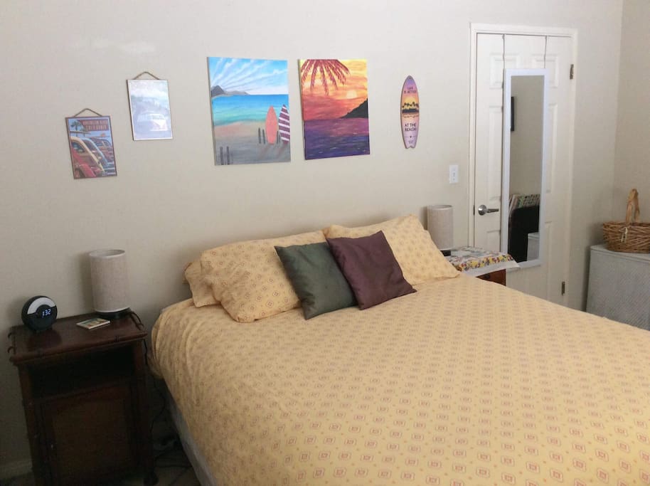 Private bedroom with queen bed, armoire dresser, closet, desk, luggage rack, TV and ceiling fan.
