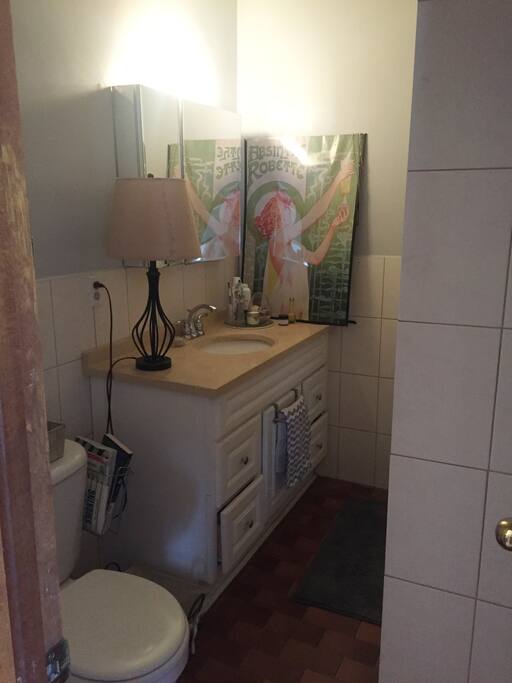 This bathroom has lots of storage room for toiletries, and the toilet includes a Tushy attachment (it's a bidet!)