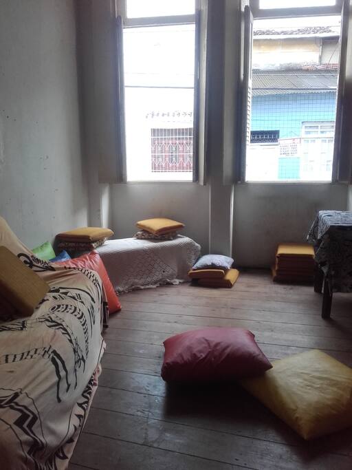 Sala da frente com sofa cama mesa de trabalho e almofadas
