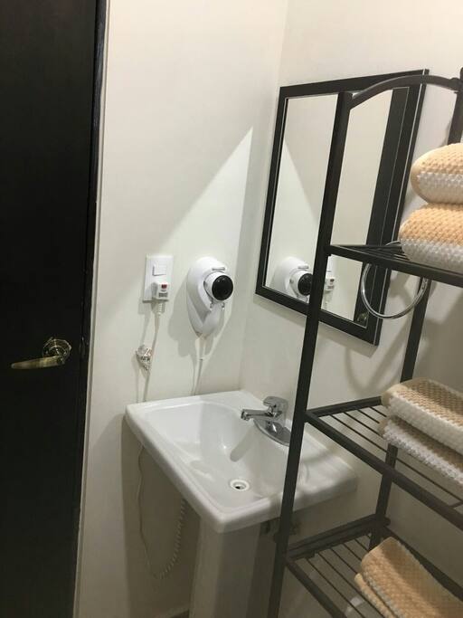 Baño completo con secadira de cabello, toallas, Shampoo, jabón y papel de baño.