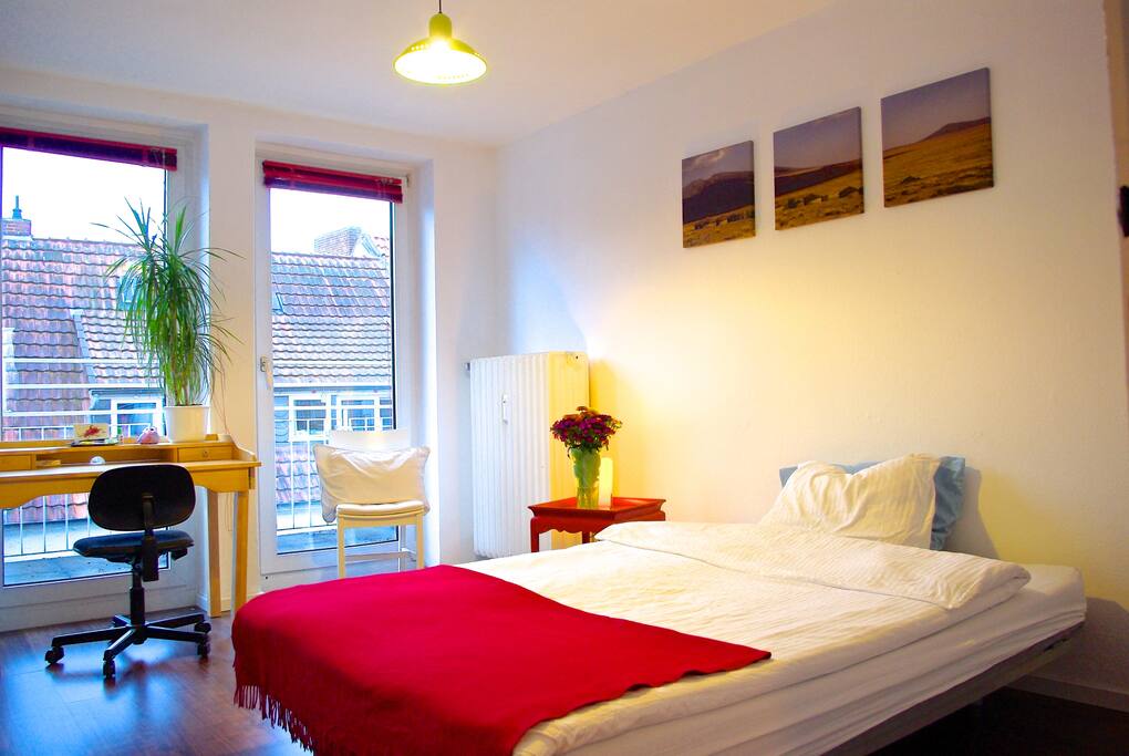 Gästezimmer mit Schlafcouch (140x200), Lesesessel, Nachttisch, Schreibtisch, Regal, und Zugang zum 9m Balkon