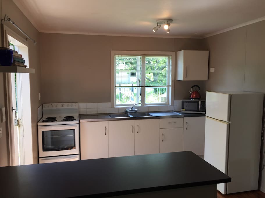 Kitchen. Fully equipped. Basic pantry supplies available. Clean. Tidy. Looks out into the garden and stream. French doors onto the deck.