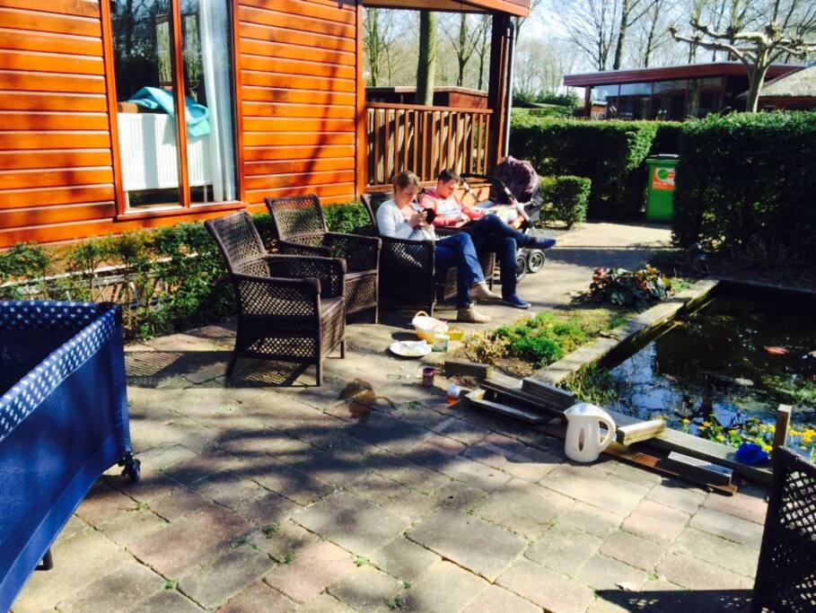 terras aan vijver met veel privecay en houtkachel
