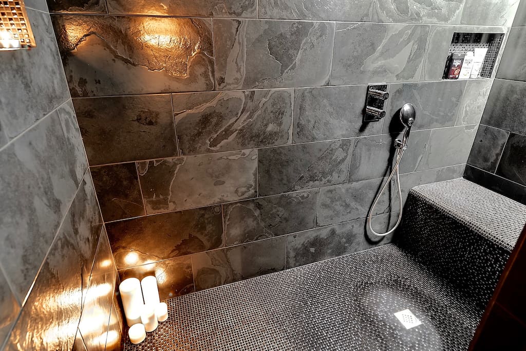Natural stone shower for 2 with ceiling rain shower & cascade + 4 jet hand shower + very large seat for 2. The dark shower lit by candles is magical.... A sensory escape from the world.