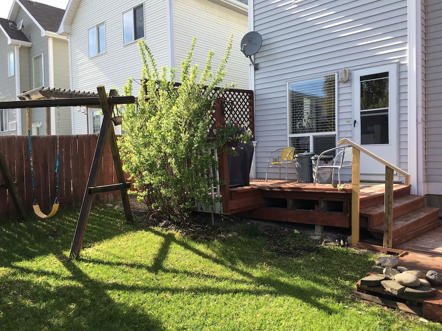 Backyard Patio with children's swing, and BBQ on patio.
