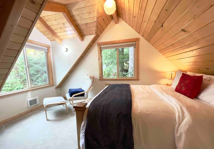 El segundo dormitorio de arriba tiene una cama tamaño queen, cortinas opacas y vistas a Otter Cove.