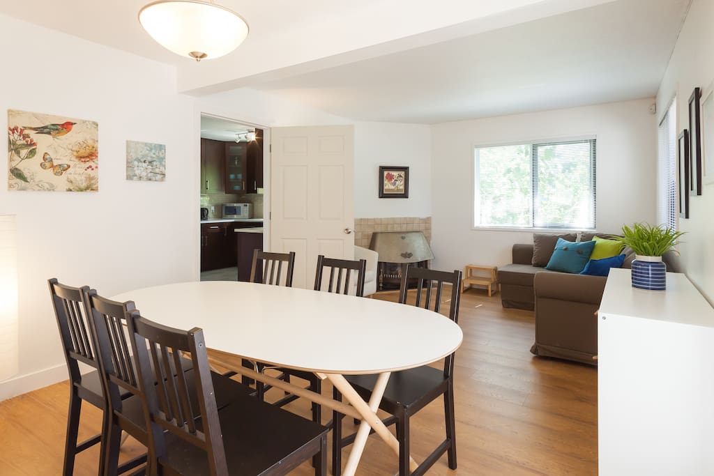 Main floor dining/family room with kitchen through the door on the left. West and south facing windows. Hardwood floor.