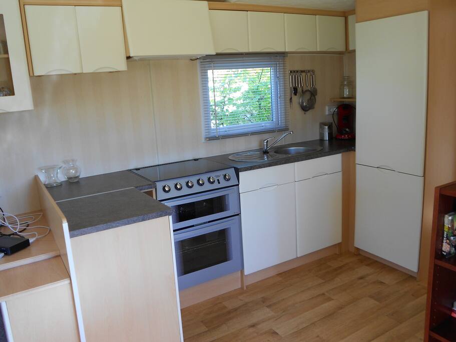 Ruime keuken met koel-vriescombinatie, oven en grill.