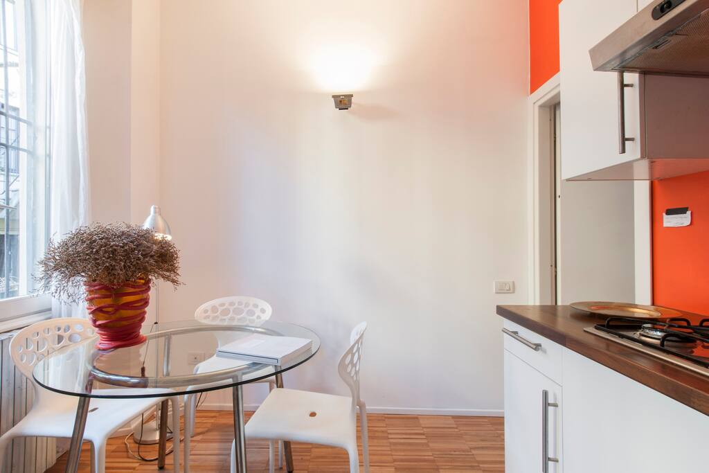 living area with table for four and open-plan kitchen